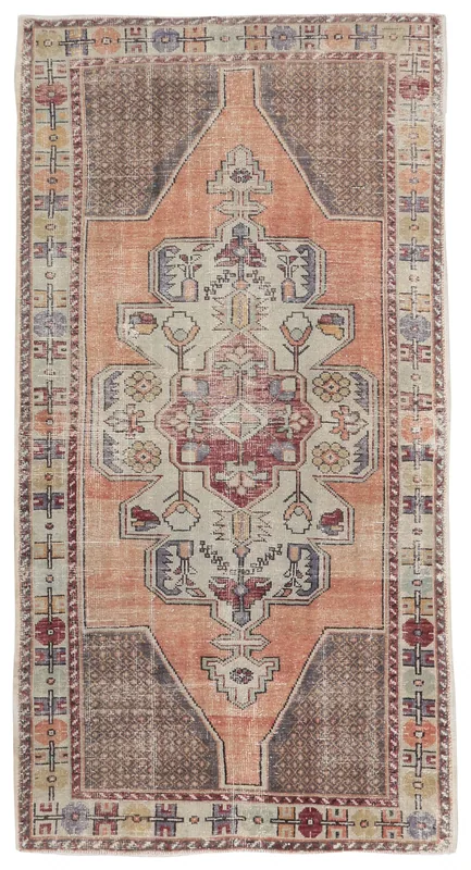 Full overhead view of the rust and beige tribal medallion vintage rug on a white background