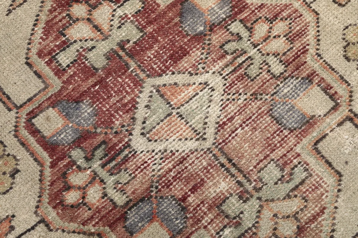 Macro detail of the central motif, highlighting the texture and color variations of the wool pile