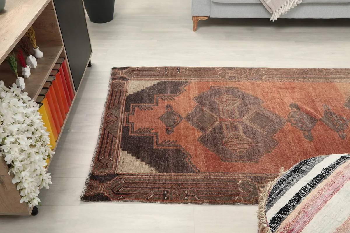 View of the runner rug from above, showing its placement next to a light-colored pouf