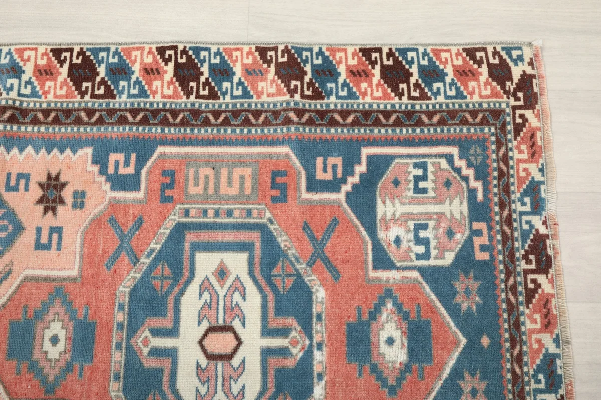 Detailed view of the rug's upper right corner, showing border patterns and colors