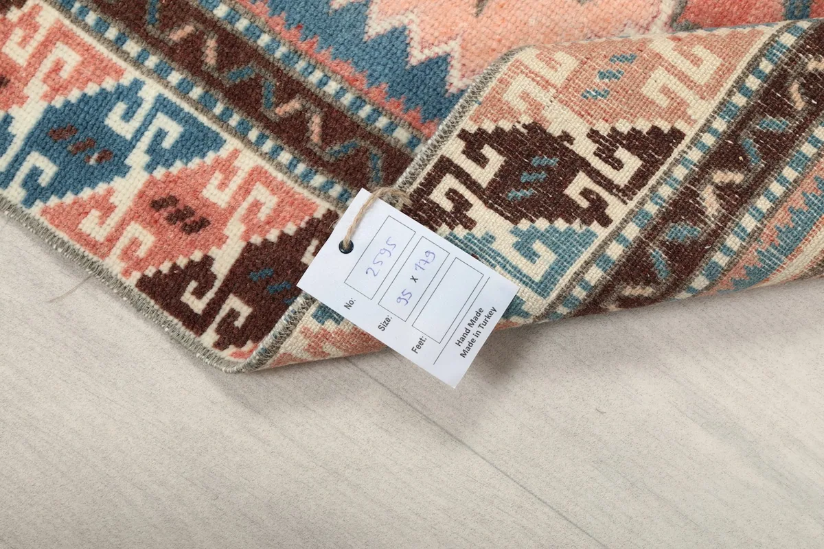 Back of the rug with a label, showing the hand-knotted construction and material