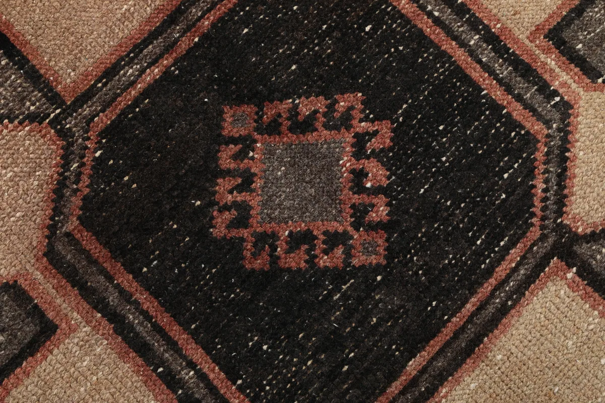 Close-up of the hand-knotted wool pile and intricate central motif