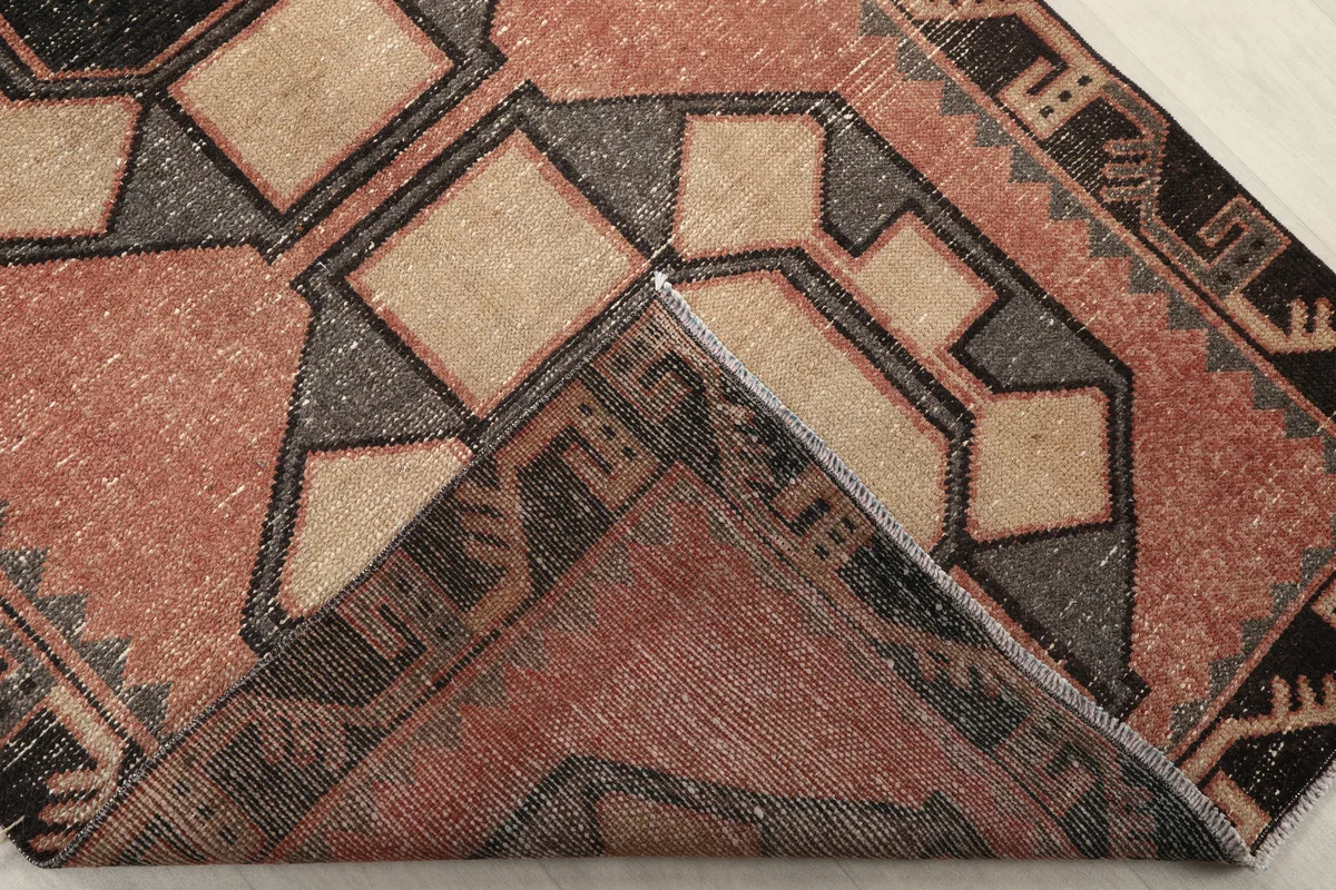 Folded corner of the runner revealing the wool pile and cotton foundation
