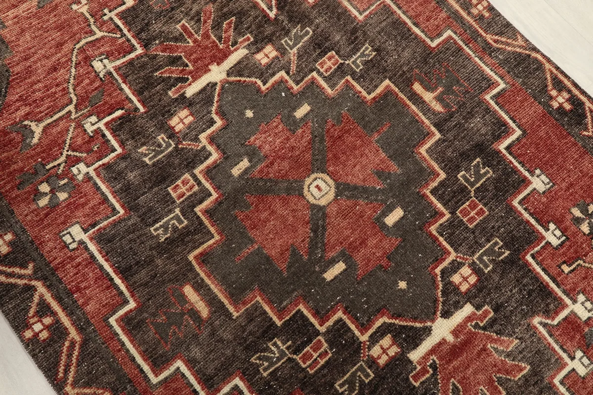 Close-up of the central geometric medallion with red, charcoal, and beige details