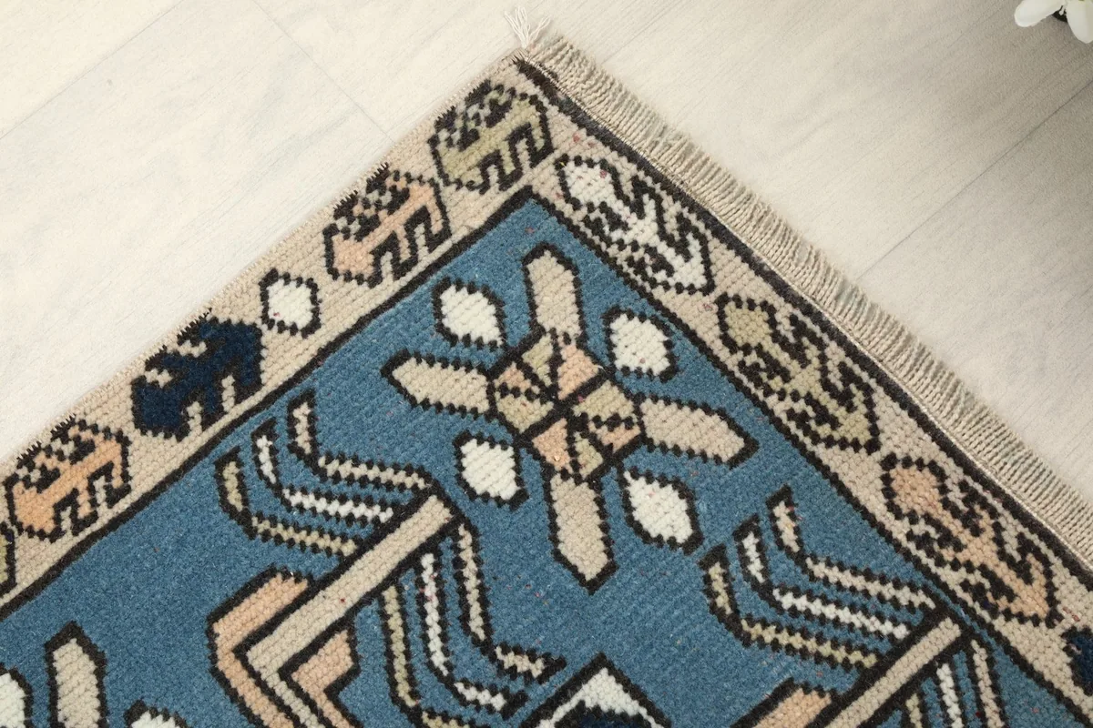 Corner detail of the rug showing the woven fringe and border patterns