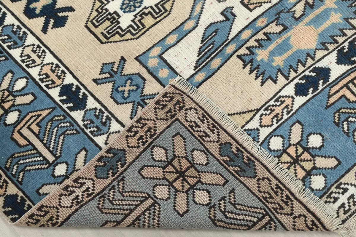 Folded corner of the rug revealing the back and thickness of the hand-knotted wool pile