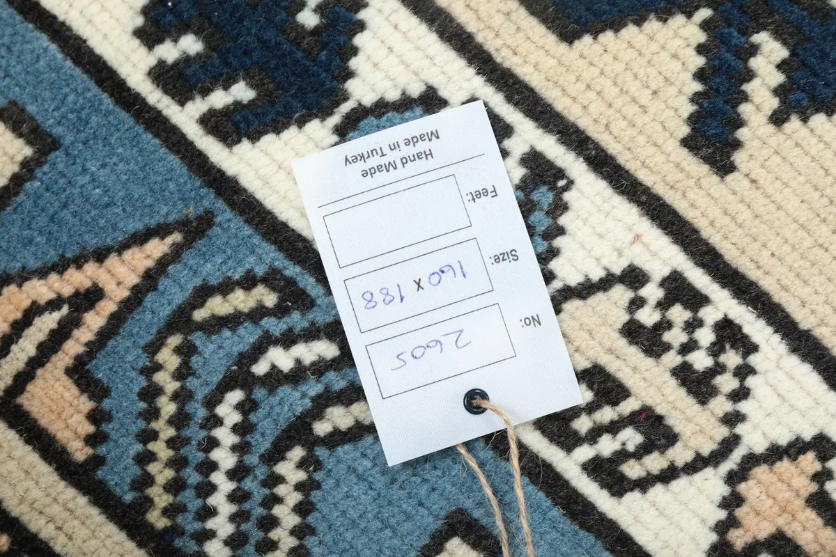 Tag on the rug displaying size in centimeters and 'Hand Made in Turkey'