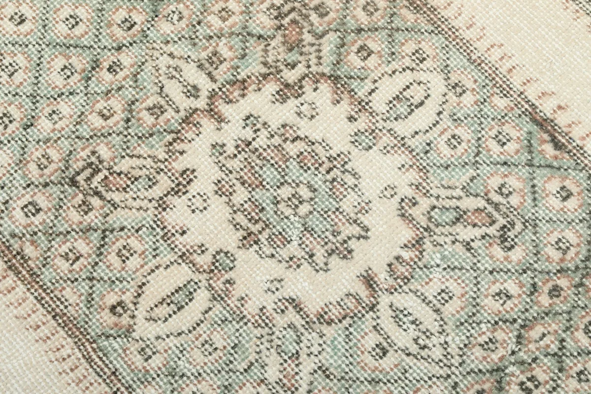 Close-up of the central medallion design, showing the intricate knotting and color variation