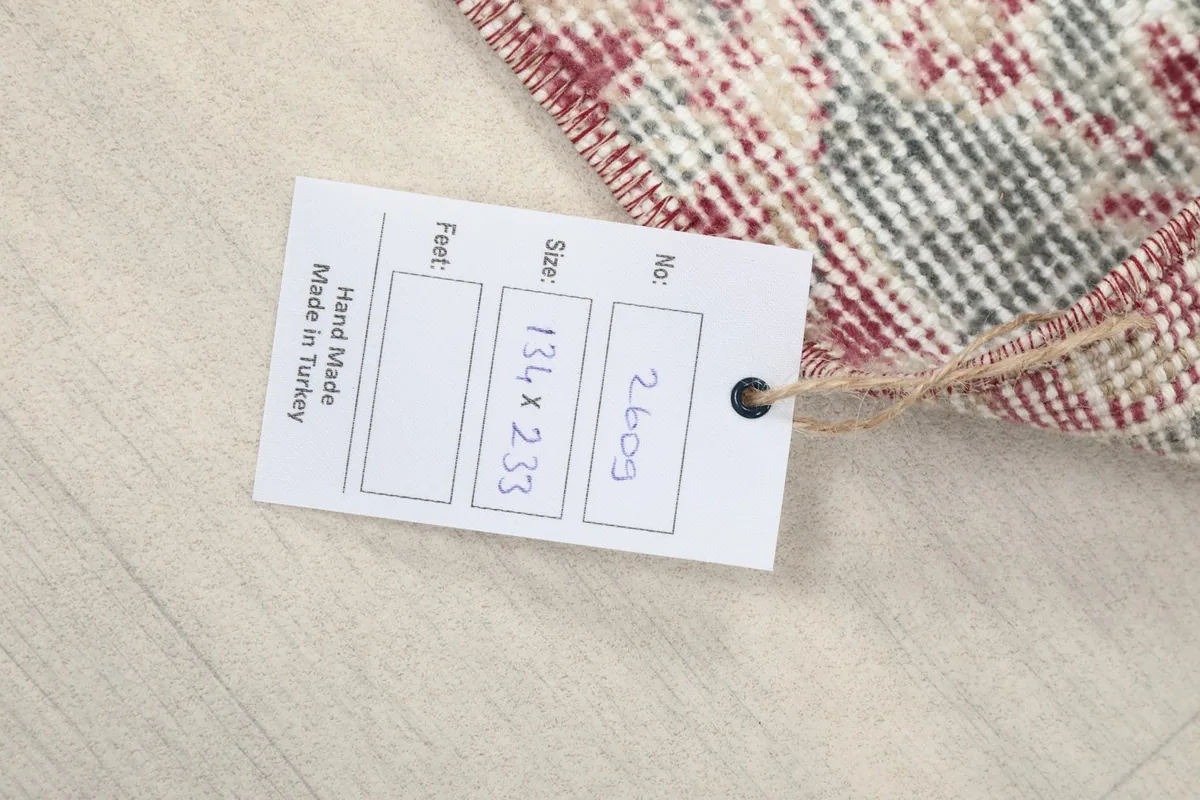 Close-up of the product tag indicating hand-made origin and size in cm