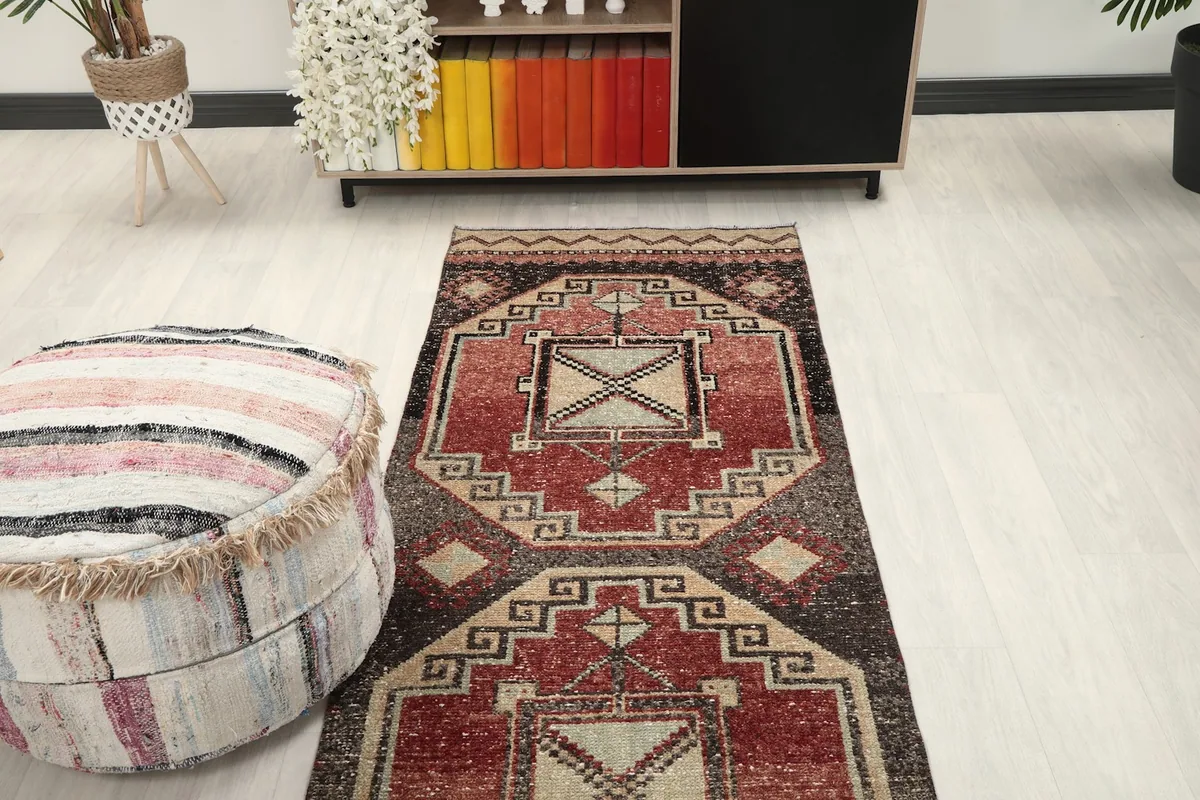 Overhead view of the runner rug in a room setting, positioned with an ottoman and part of a living space