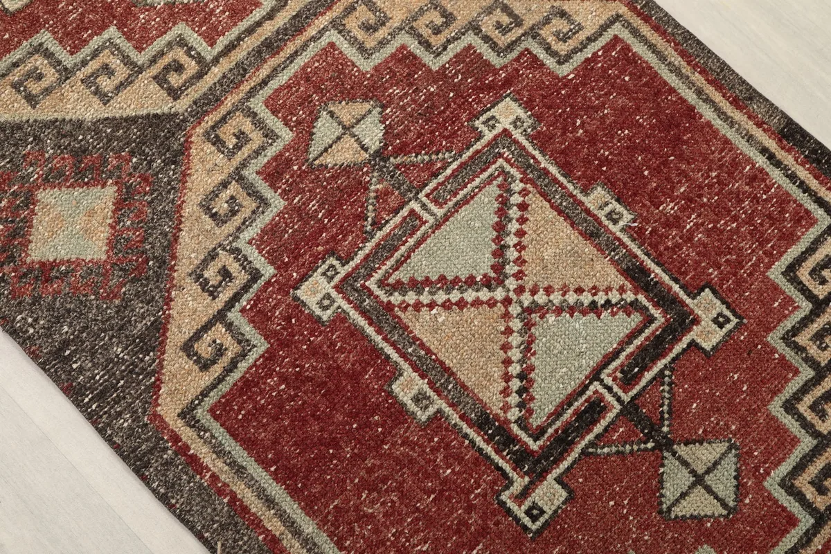 Close-up of a central geometric medallion on the runner, featuring rust, beige, and gray elements