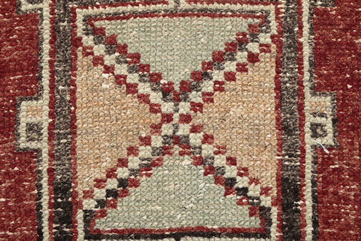 Extreme close-up of the hand-knotted wool pile and intricate pattern within a medallion, showing texture