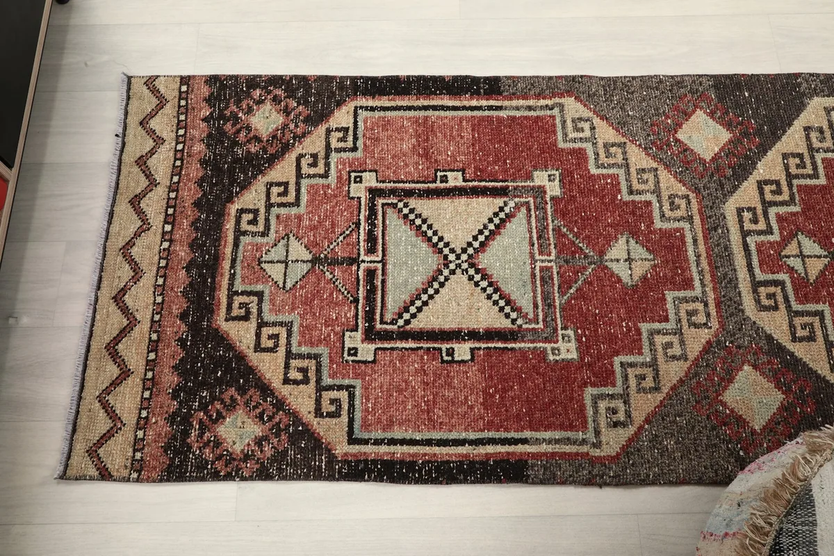 Overhead view of a section of the runner rug, focusing on the repeating geometric motifs and color palette