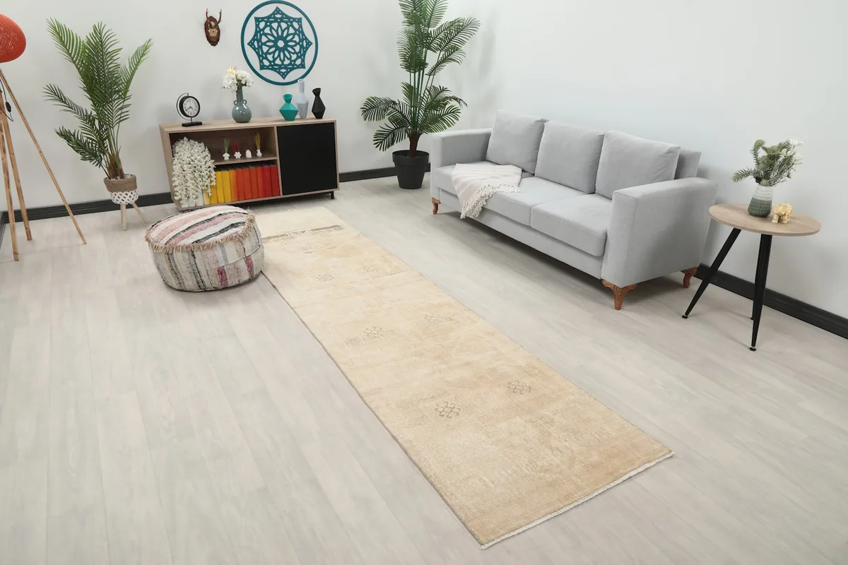 Angle view of the tan runner rug in a room, showing its length and placement