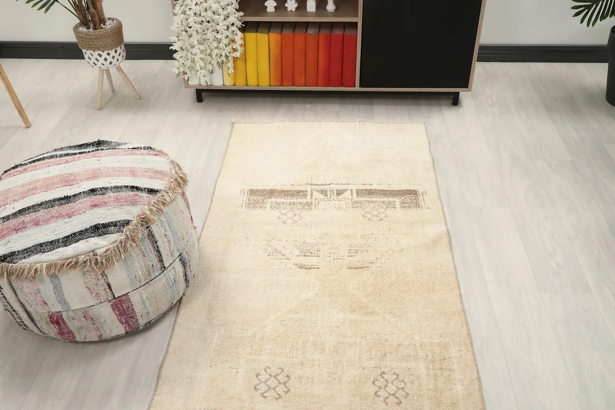 Overhead view of the end of the tan runner rug in a room setting