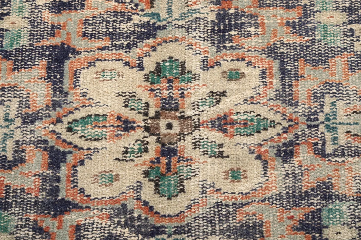Close-up detail of the hand-knotted wool pile and floral motif within the medallion
