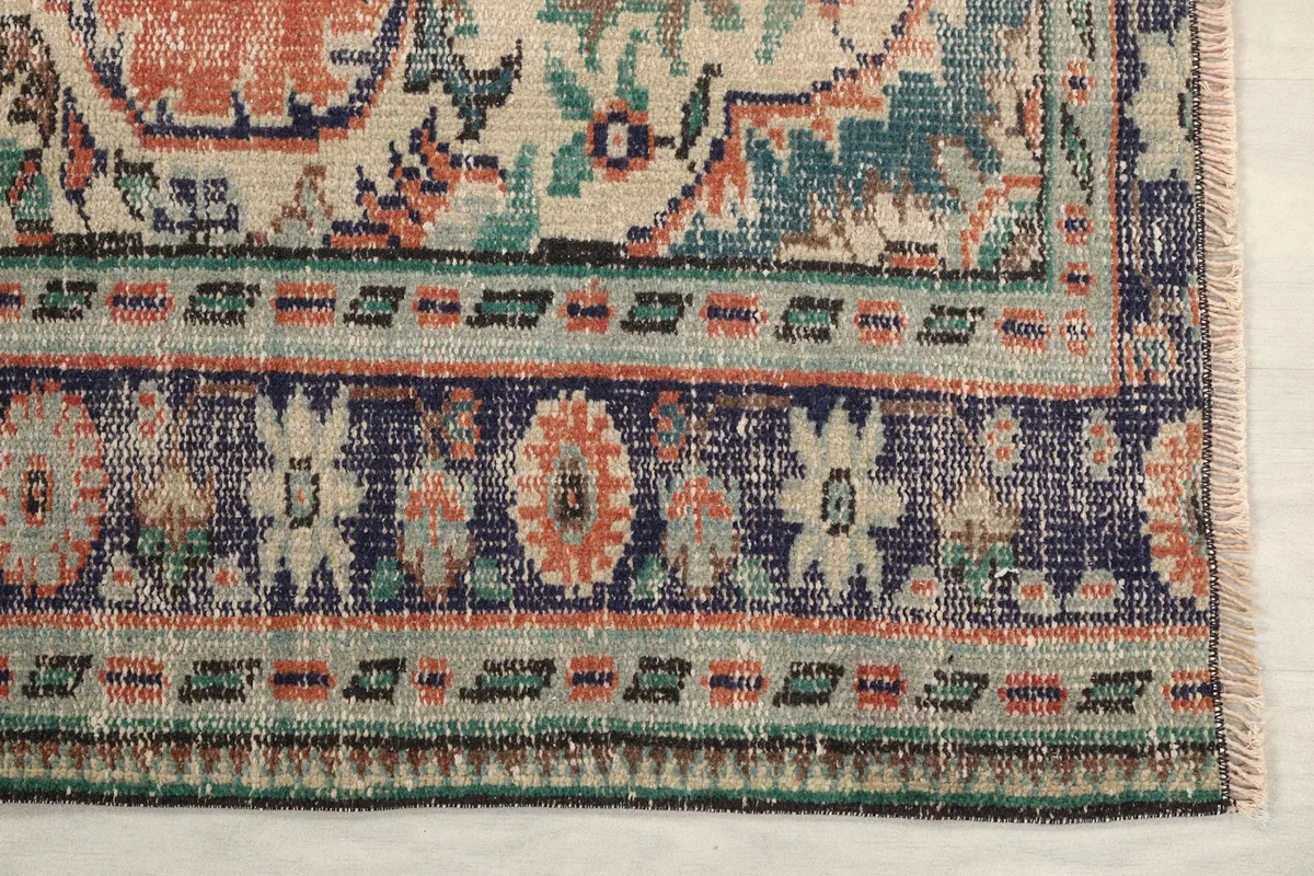 Detailed view of the intricate navy and cream border patterns on the rug