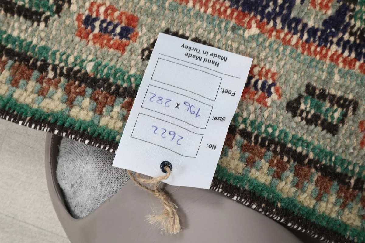 Rug tag displaying the size 196 x 282 cm and hand-made in Turkey origin