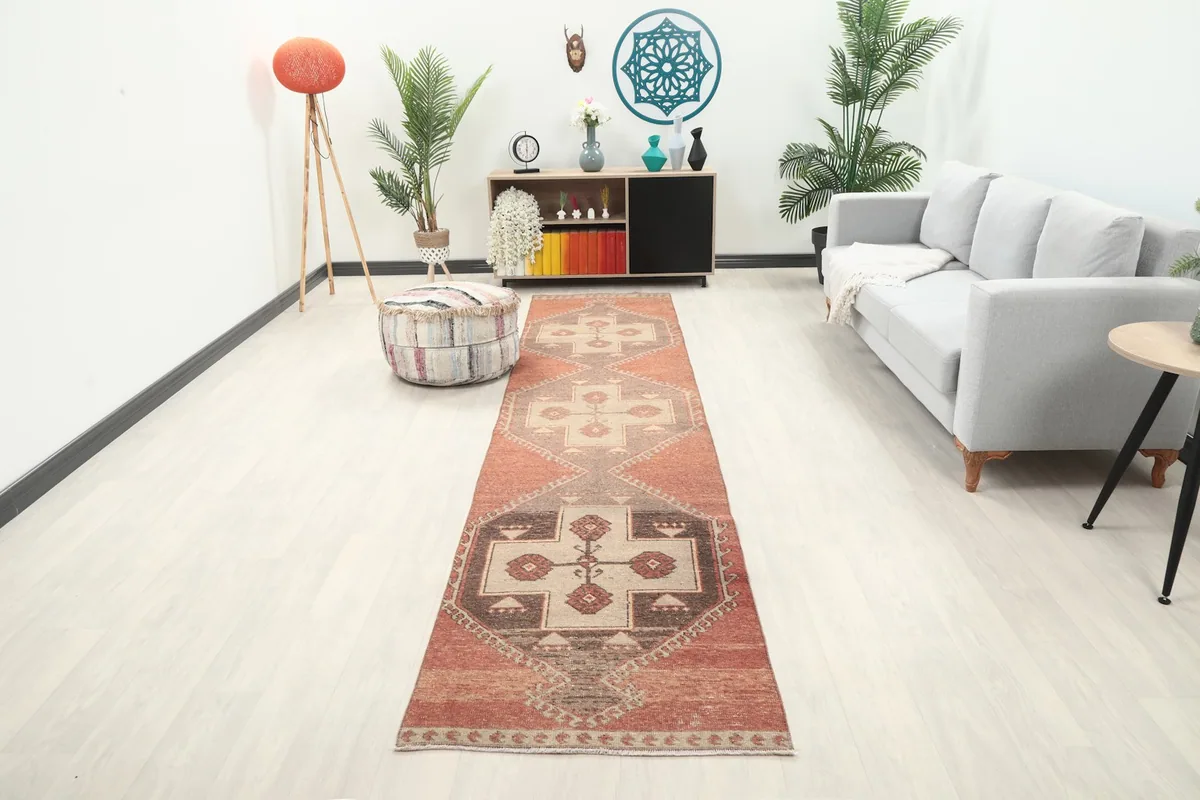 Vintage runner rug in a modern living room setting with a light gray couch and ottoman