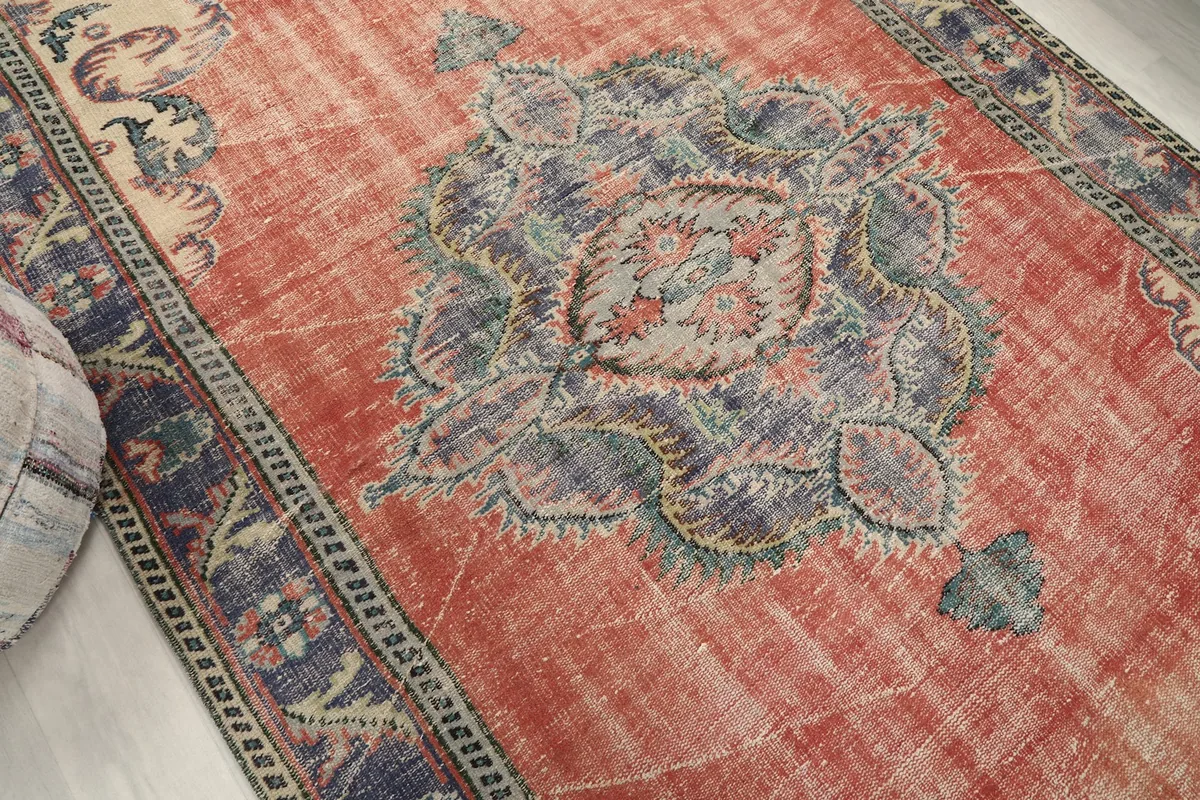 Overhead angle of the vintage rug highlighting the central design and color variations