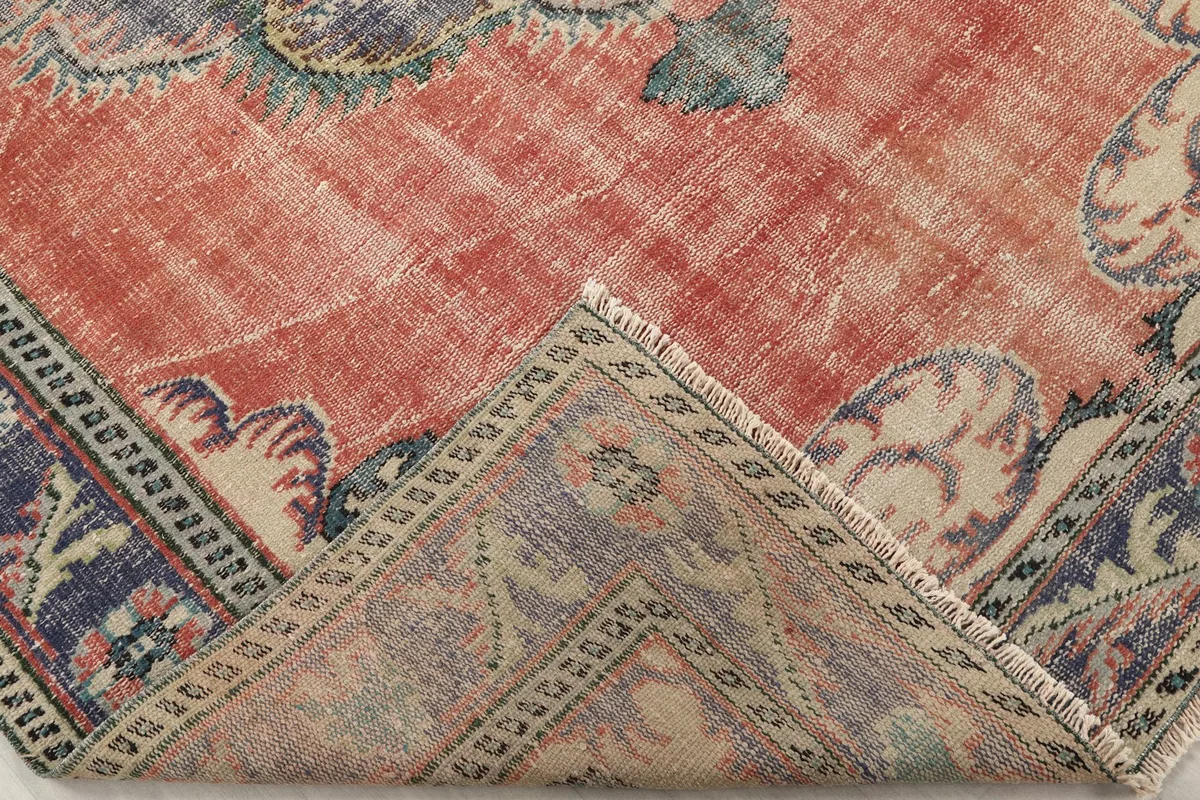 Folded corner of the rug revealing the back and thickness of the wool pile