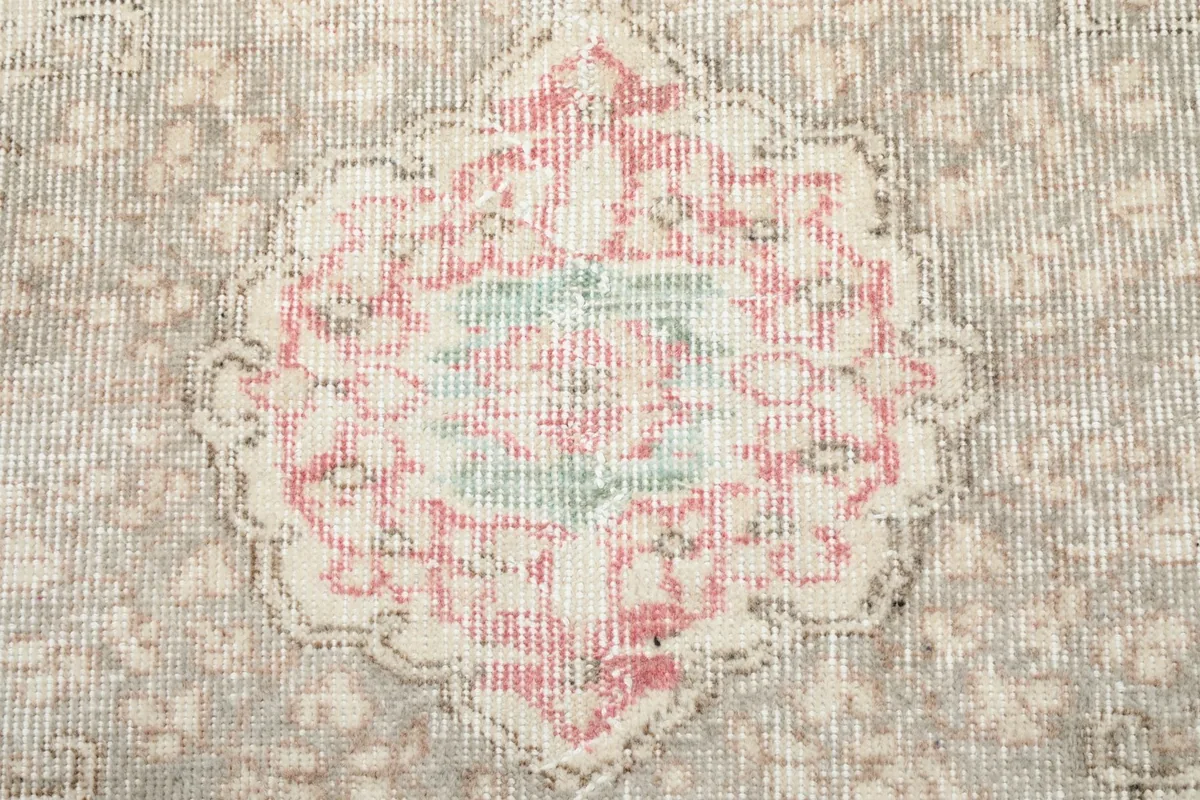 Tight close-up of the central medallion design with rose and green accents