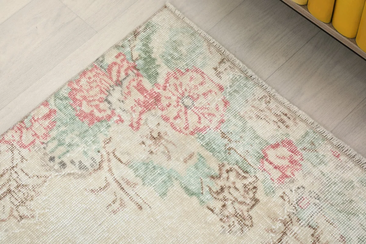 Detailed view of a corner of the rug, showing the floral border pattern