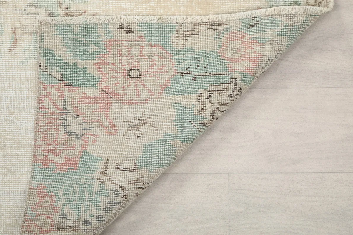 Folded corner of the rug showing the reverse side with visible knots and foundation