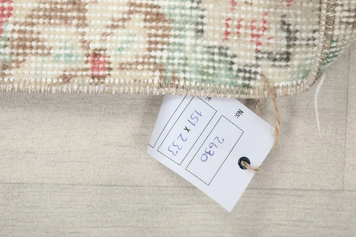 Close-up of the rug's edge with a tag showing its size in centimeters
