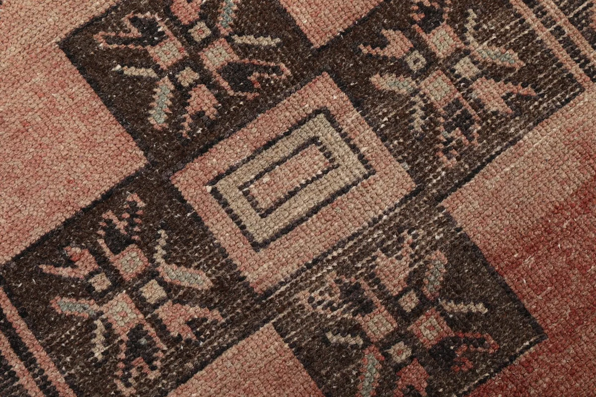 Extreme close-up showing the low wool pile and texture of the hand-knotted vintage rug