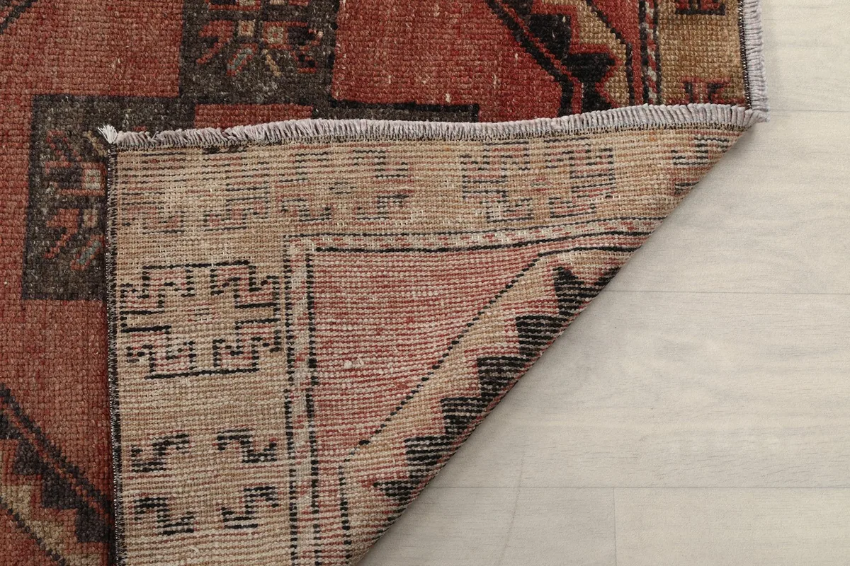 Another view of the rug's back, showing the hand-knotted construction and fringe detail