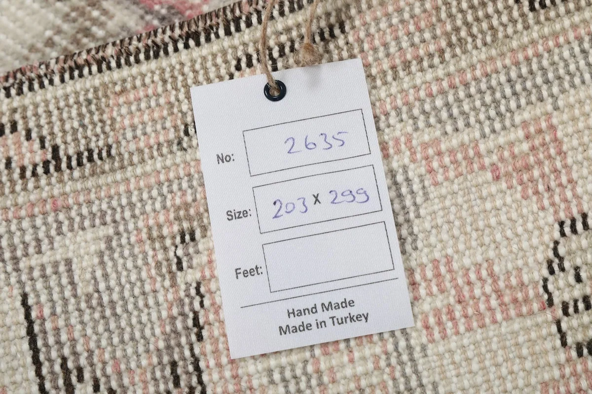 Tag showing the rug's inventory number and dimensions in centimeters, confirming handmade origin