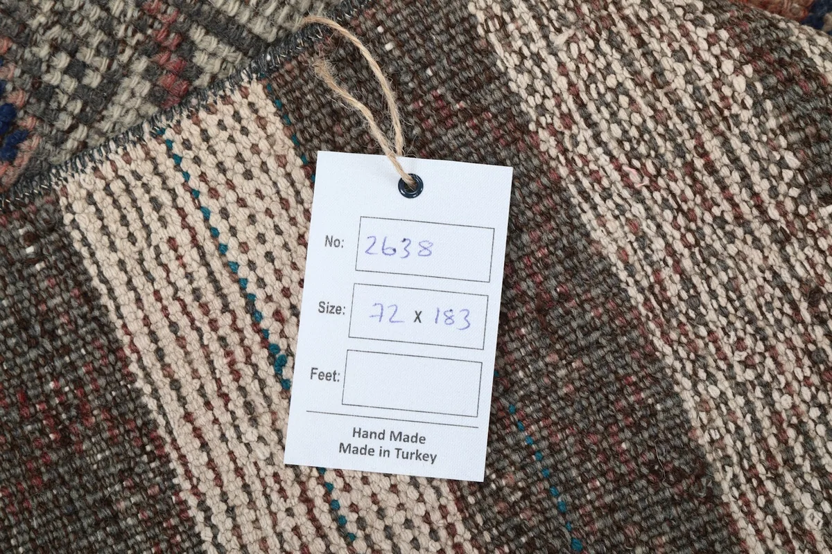 Close-up of the rug's back with a size and origin tag, showing hand-made details