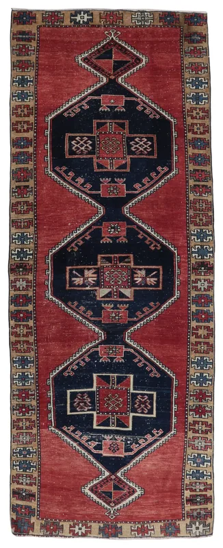 Full overhead view of the red and navy geometric Anatolian runner on a white background