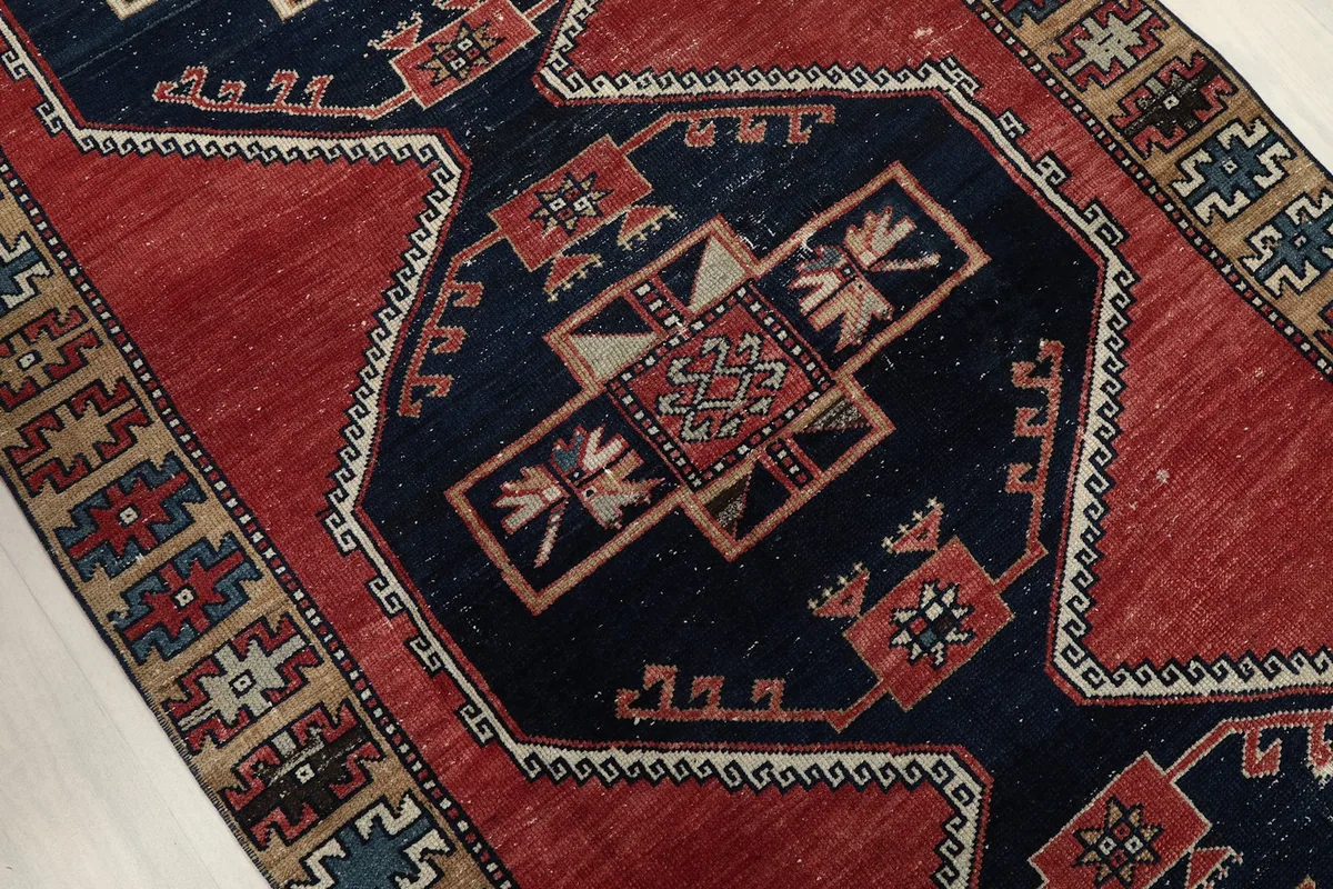Close-up of the central navy medallion with intricate red, tan, and white tribal motifs