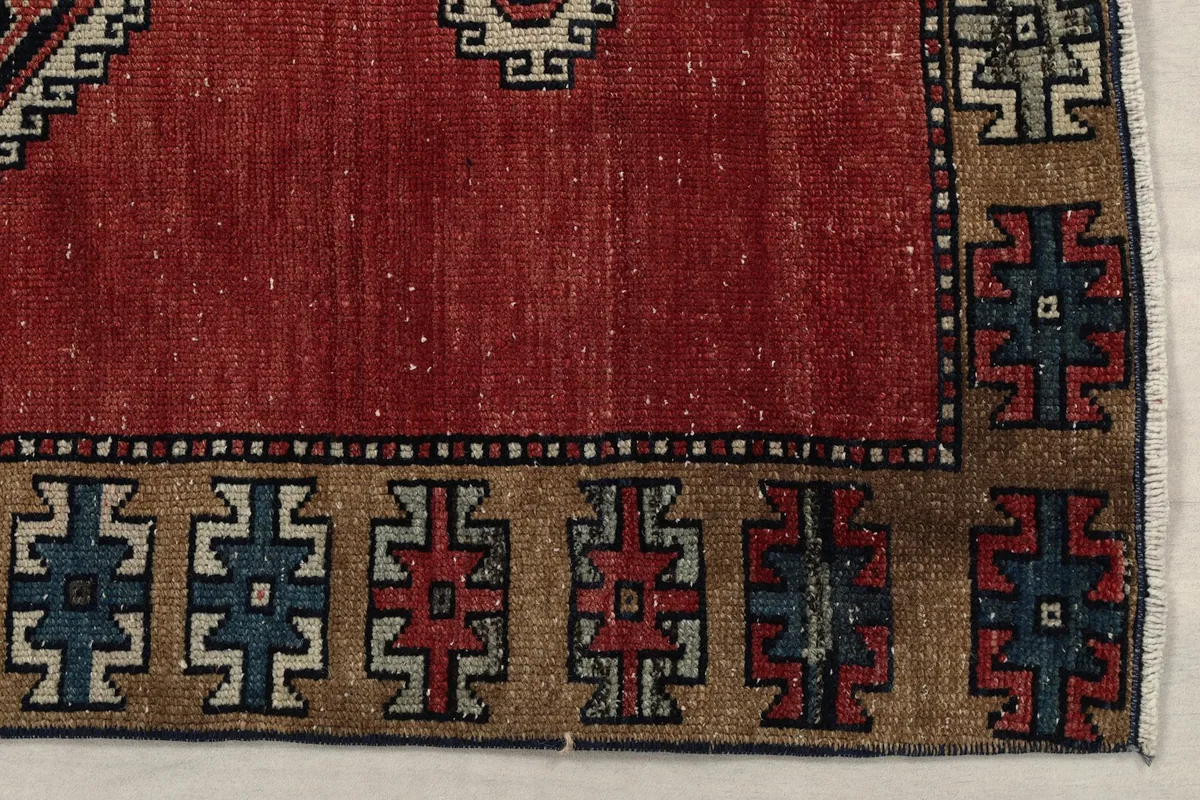 Detail of the rug's tan border with blue and red geometric elements