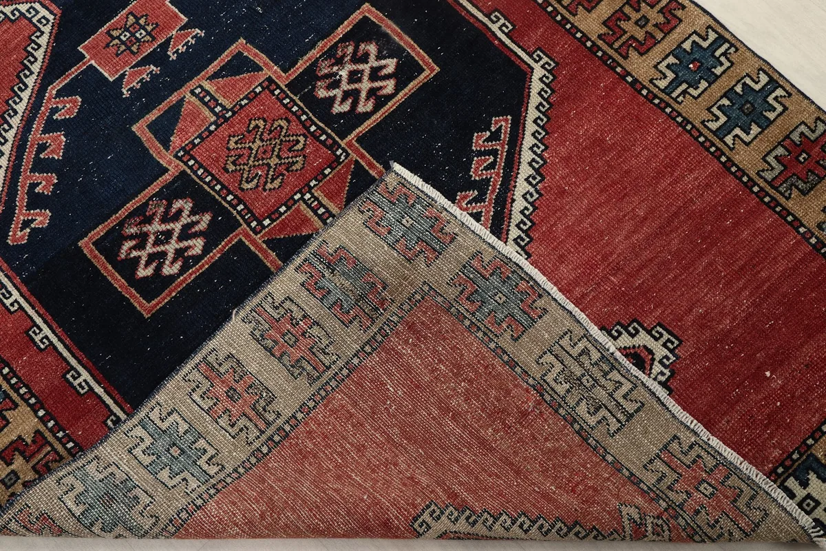 Corner of the rug folded back to show the hand-knotted cotton foundation