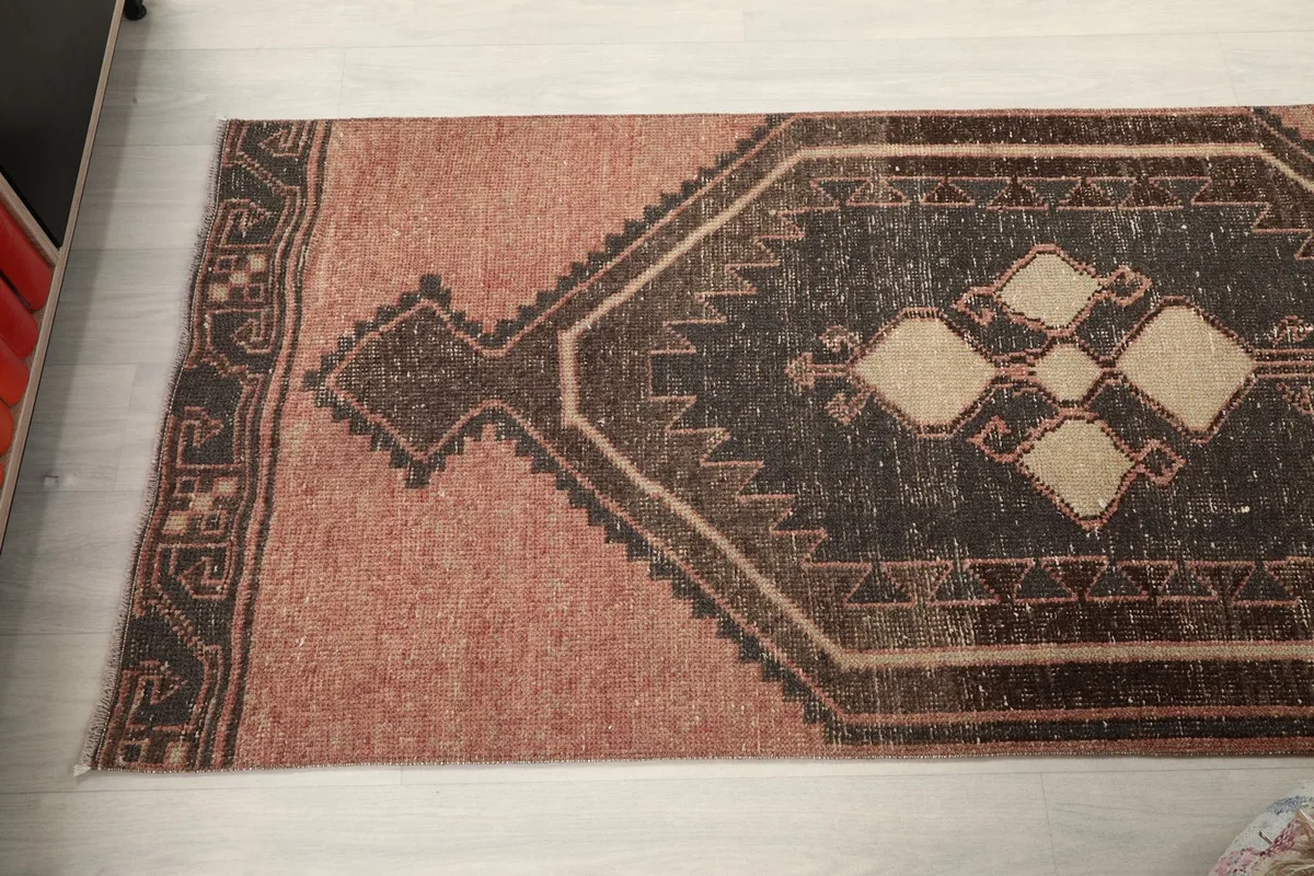 Angled view showing the full width of the runner and one of its charcoal medallions