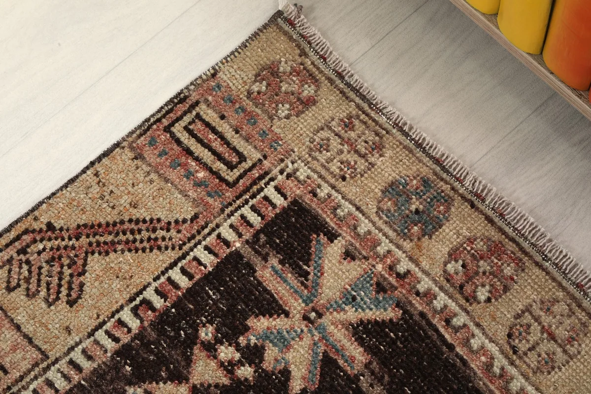 Corner detail showing the distinct border pattern and the short, natural fringe