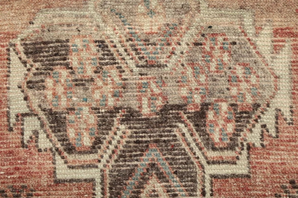 Texture detail of the low wool pile and hand-knotted construction showing slight wear