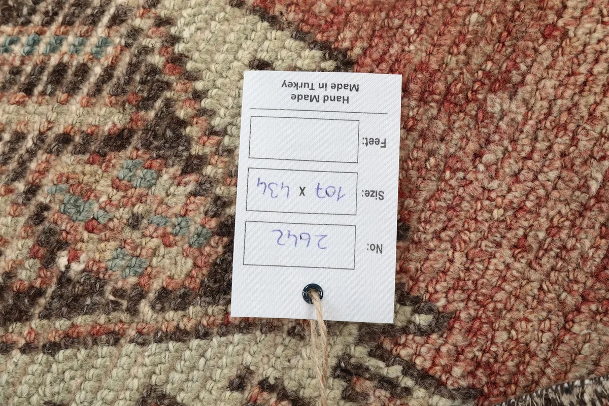 Tag displaying the rug's dimensions in centimeters and feet, and its origin as hand made in Turkey