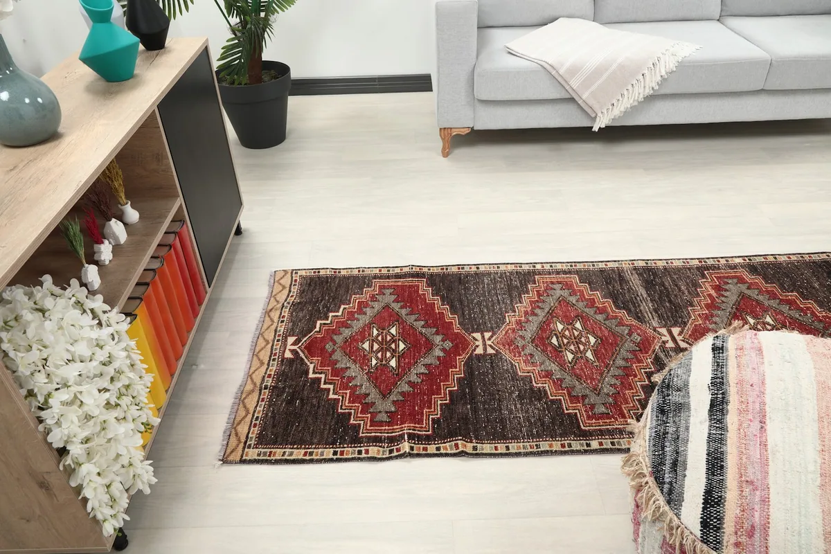 Long view of the runner rug in a room, extending from a cabinet towards a sofa