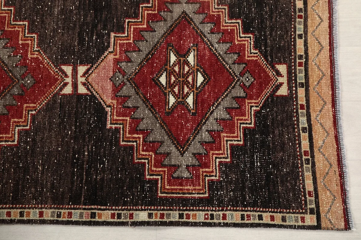 Detailed view of a red and gray geometric motif on the black field