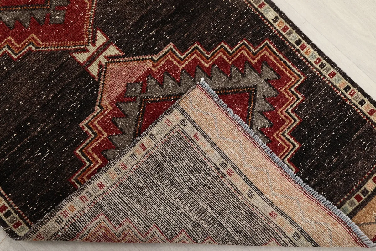 Folded corner showing the back of the hand-knotted wool runner and its cotton foundation
