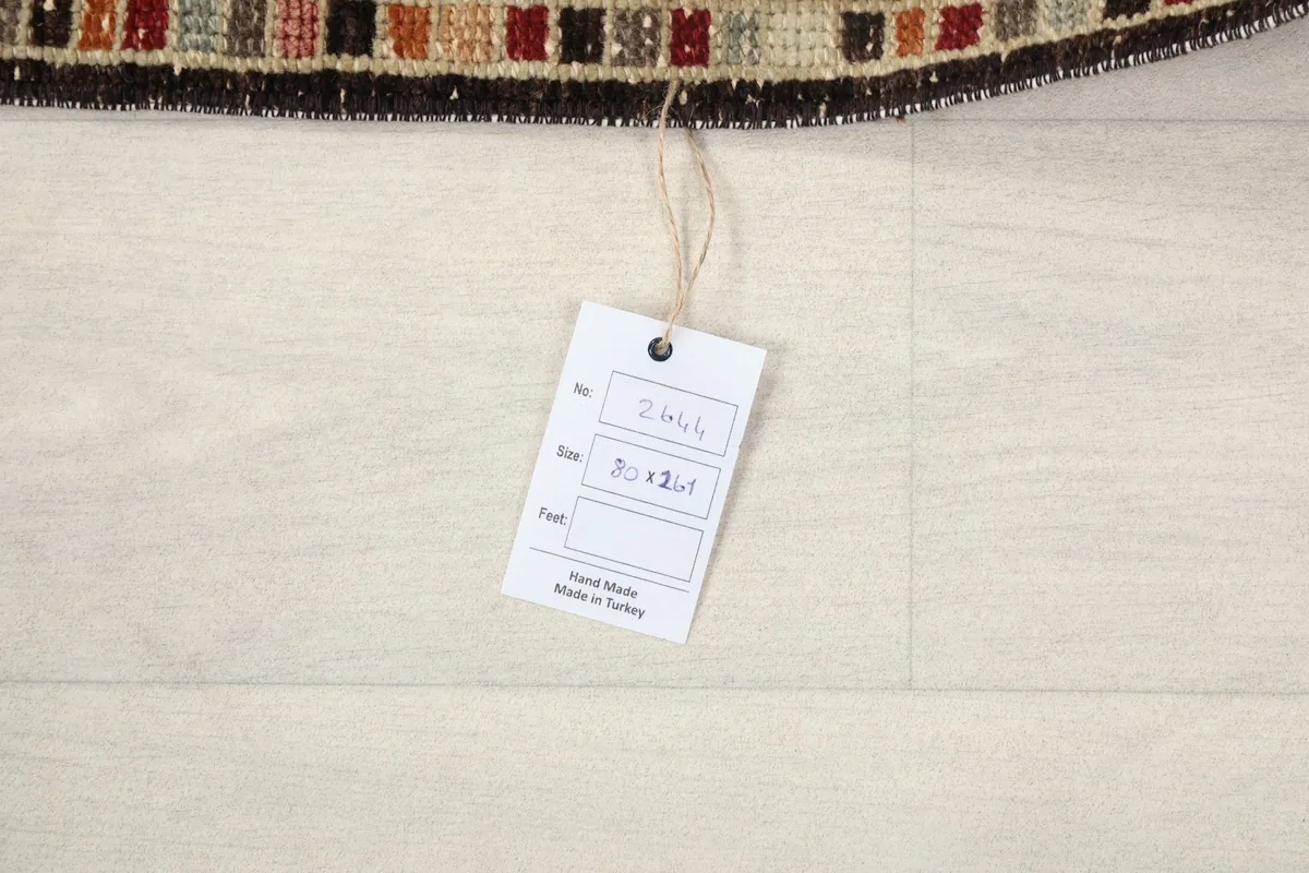 Product tag displaying the rug's dimensions in centimeters and origin