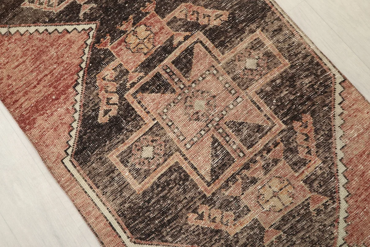 Detailed view of a central brown geometric medallion with rust and beige accents