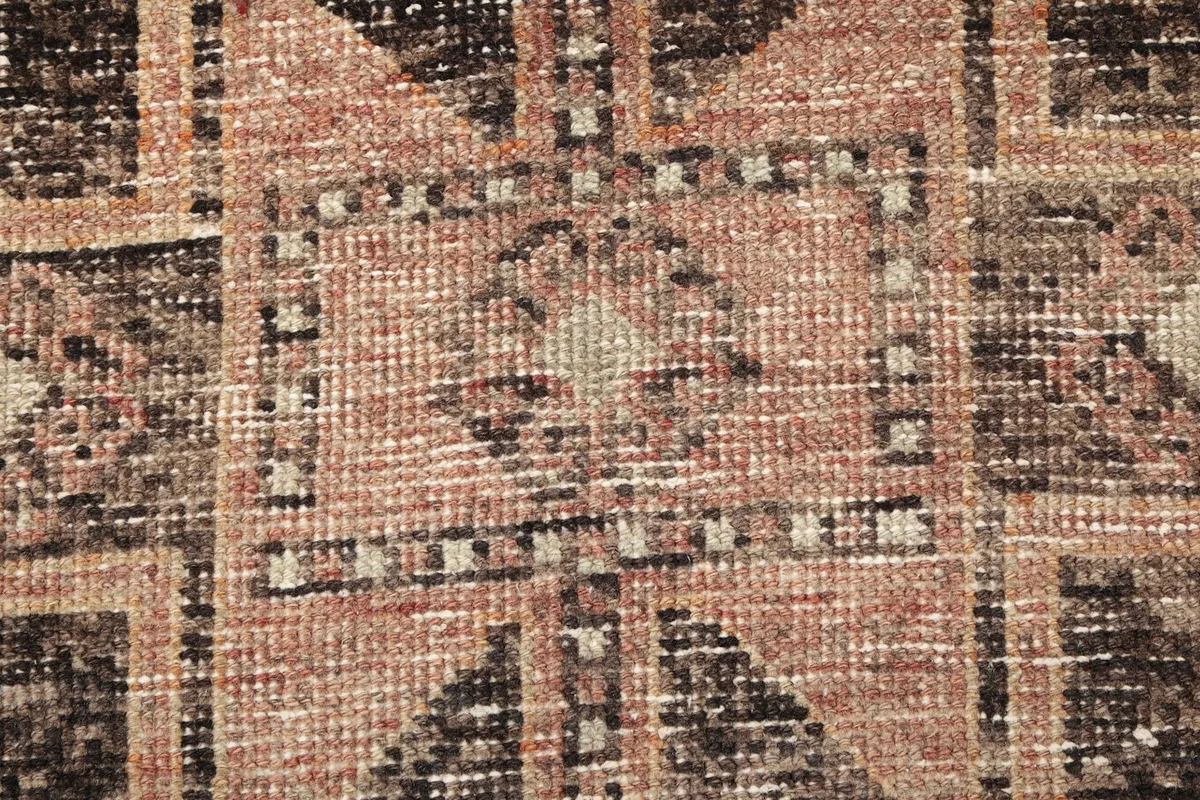 Extreme close-up showing the low wool pile and texture of the hand-knotted rug