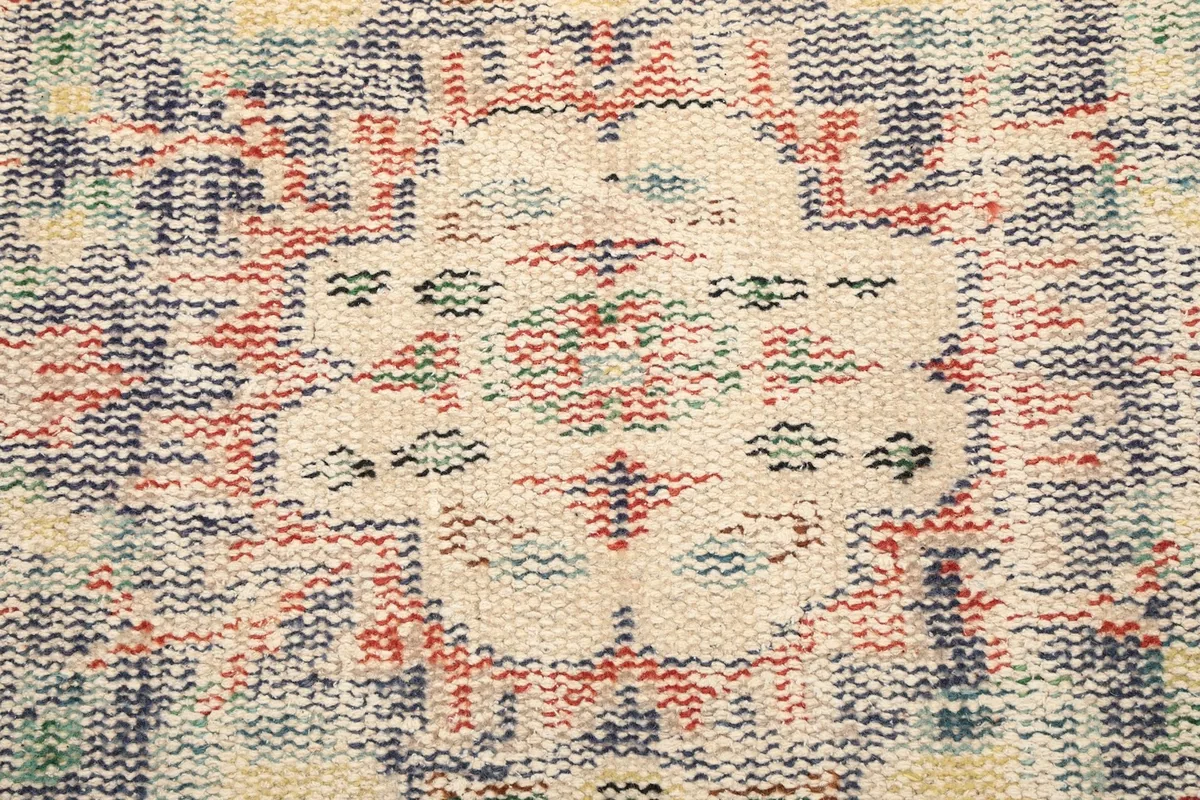 Extreme close-up of the low wool pile showing individual knots and color variations in the medallion