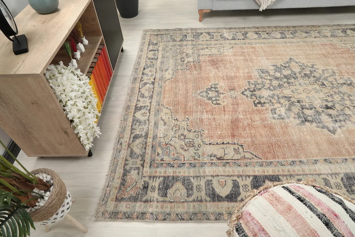 Side view of the rust and blue vintage rug in a living room, showing its length and proportion.