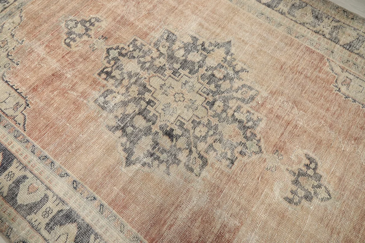 Close-up of the central blue and gray medallion and the surrounding rust field with visible patina.
